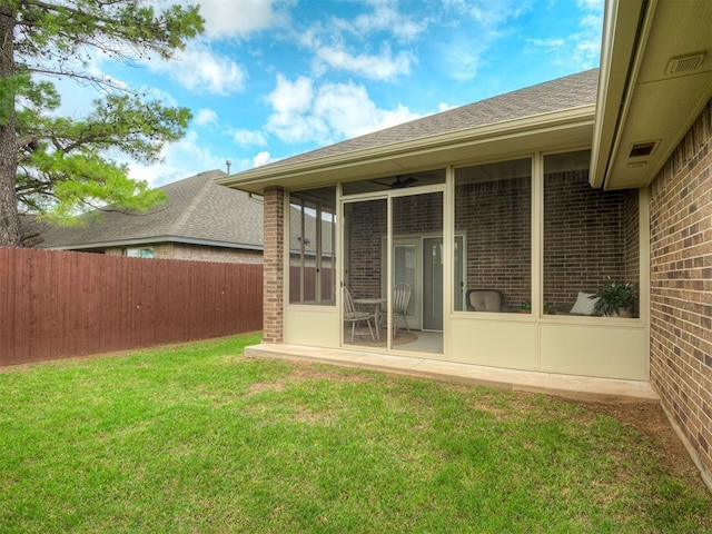 2204 Cale Cv, Yukon, OK 73099 - back of property featuring a sunroom, brick siding, and roof with shingles