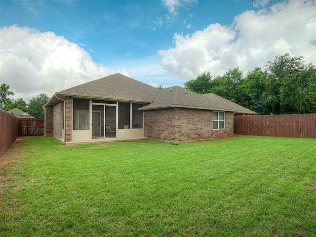 2204 Cale Cv, Yukon, OK 73099 - back of property featuring a sunroom, a fenced backyard, brick siding, and roof with shingles