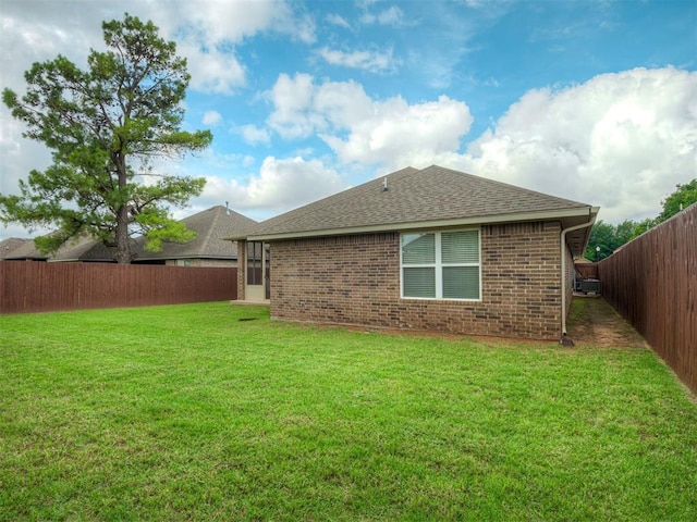 2204 Cale Cv, Yukon, OK 73099 - back of property with a fenced backyard, a shingled roof, and brick siding