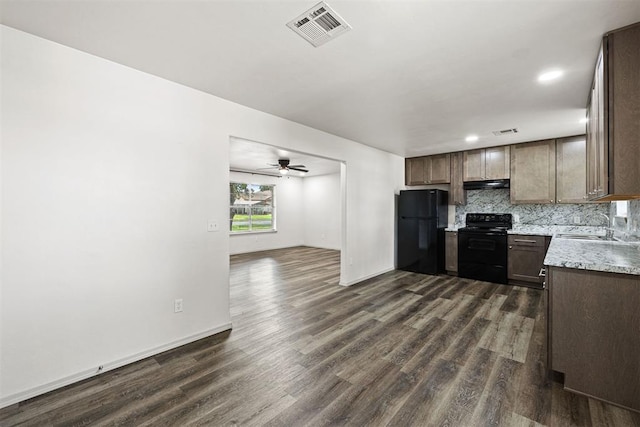 311 N Monroe Ave, Blanchard, OK 73010 - kitchen with black appliances, dark wood-type flooring, under cabinet range hood, tasteful backsplash, and ceiling fan