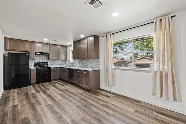 311 N Monroe Ave, Blanchard, OK 73010 - kitchen featuring black appliances, under cabinet range hood, wood finished floors, tasteful backsplash, and recessed lighting