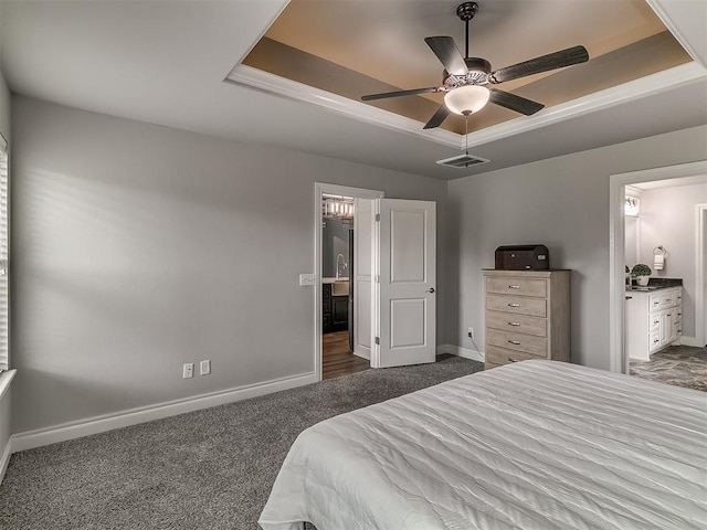 12917 Treemont Ln, Oklahoma City, OK 73142 - carpeted bedroom with a tray ceiling, ensuite bathroom, and ceiling fan