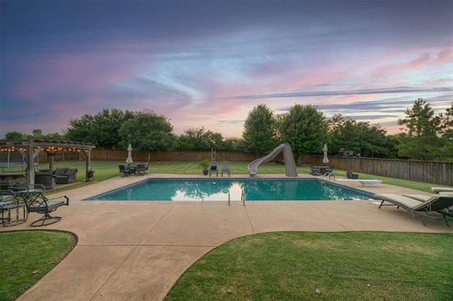 3617 Stagmoor Rd, Edmond, OK 73034 - pool at dusk featuring a water slide, a diving board, a patio area, and a fenced backyard