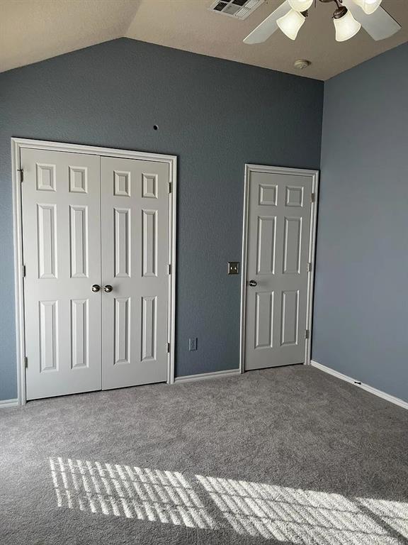 916 Beaumont Sq, Norman, OK 73071 - unfurnished bedroom featuring lofted ceiling, carpet floors, a closet, and a ceiling fan