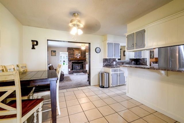 1383 N Peebly Rd, Choctaw, OK 73020 - kitchen with stainless steel refrigerator, light tile patterned floors, ceiling fan, light carpet, and decorative backsplash