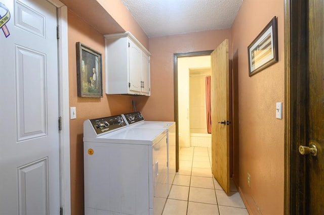 1383 N Peebly Rd, Choctaw, OK 73020 - laundry room with washing machine and clothes dryer, cabinet space, light tile patterned floors, and a textured ceiling