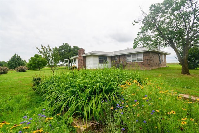 1383 N Peebly Rd, Choctaw, OK 73020 - view of side of home featuring brick siding, a chimney, and a yard