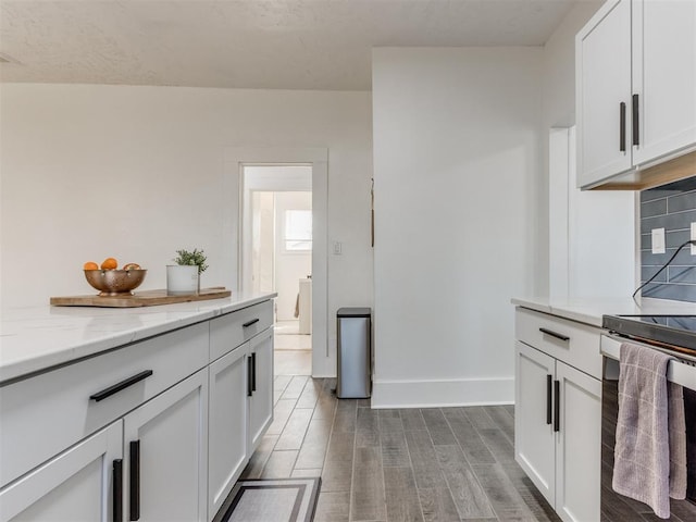 1317 N Wisconsin Ave, Oklahoma City, OK 73117 - kitchen with range, dark wood finished floors, white cabinets, and light stone counters