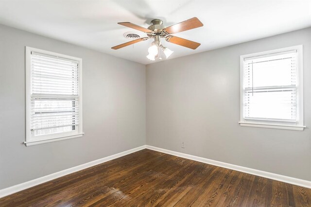 3012 NW 67th St, Oklahoma City, OK 73116 - empty room with plenty of natural light, dark wood finished floors, and a ceiling fan