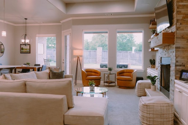 12113 SW 45th Ter, Mustang, OK 73064 - carpeted living area featuring a fireplace, a chandelier, and a raised ceiling