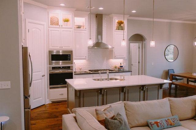 12113 SW 45th Ter, Mustang, OK 73064 - kitchen with appliances with stainless steel finishes, wall chimney exhaust hood, open floor plan, crown molding, and tasteful backsplash