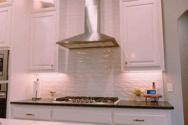 12113 SW 45th Ter, Mustang, OK 73064 - kitchen featuring wall chimney exhaust hood, tasteful backsplash, white cabinets, stainless steel appliances, and arched walkways