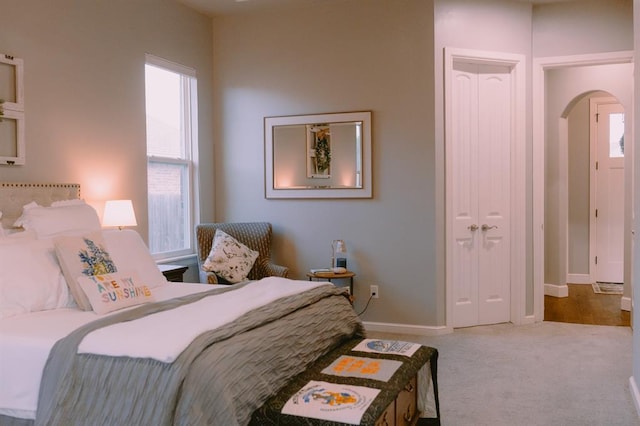 12113 SW 45th Ter, Mustang, OK 73064 - bedroom featuring arched walkways, carpet flooring, and a closet