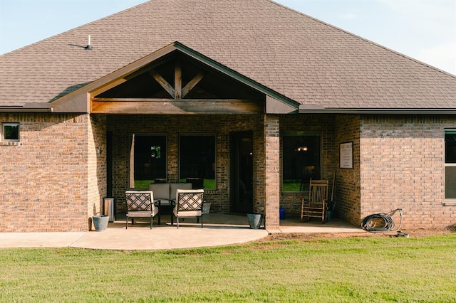 12113 SW 45th Ter, Mustang, OK 73064 - entrance to property with a yard, brick siding, a shingled roof, and a patio area