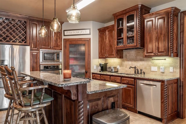 4417 Man O War Dr, Edmond, OK 73025 - kitchen featuring appliances with stainless steel finishes, decorative backsplash, light stone countertops, and glass insert cabinets