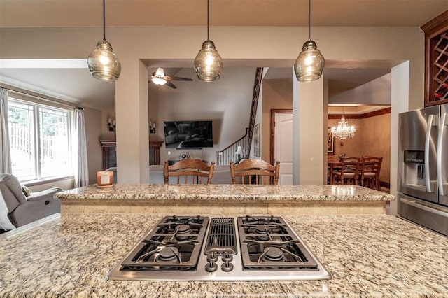 4417 Man O War Dr, Edmond, OK 73025 - kitchen with stainless steel refrigerator with ice dispenser, stovetop with downdraft, a chandelier, light stone countertops, and ceiling fan