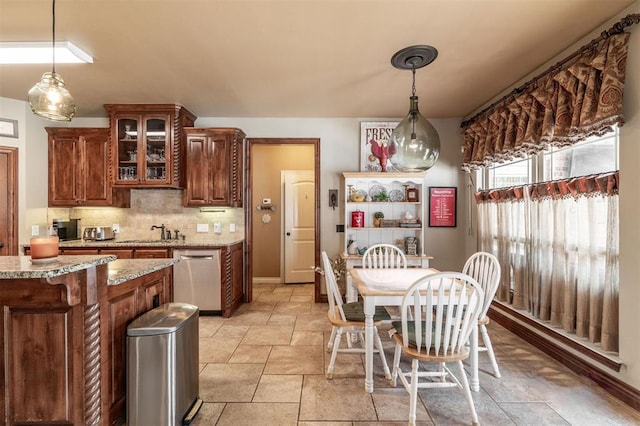 4417 Man O War Dr, Edmond, OK 73025 - kitchen featuring dishwasher, stone tile flooring, decorative backsplash, glass insert cabinets, and light stone counters