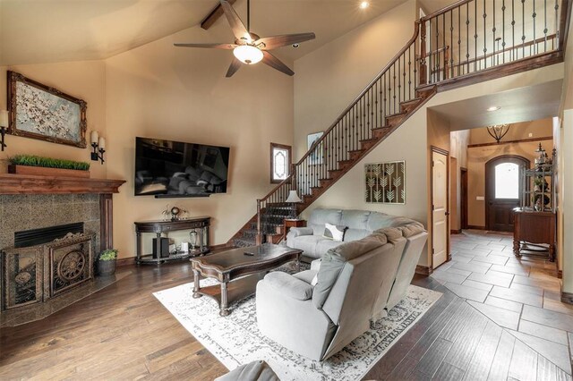 4417 Man O War Dr, Edmond, OK 73025 - living room featuring high vaulted ceiling, stairway, ceiling fan, wood finished floors, and a fireplace