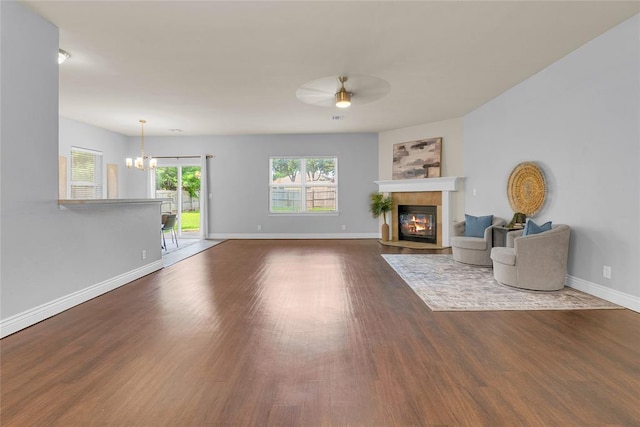 16117 Sonoma Lake Blvd, Edmond, OK 73013 - unfurnished living room featuring ceiling fan, wood finished floors, a tile fireplace, and a chandelier