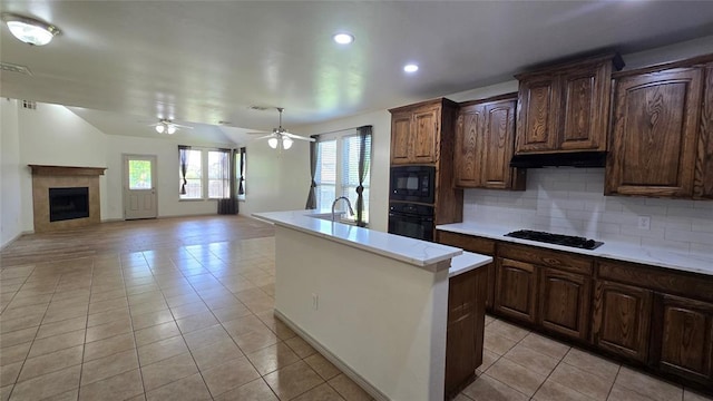3441 NW 176th St, Edmond, OK 73012 - kitchen with black appliances, light countertops, backsplash, an island with sink, and recessed lighting