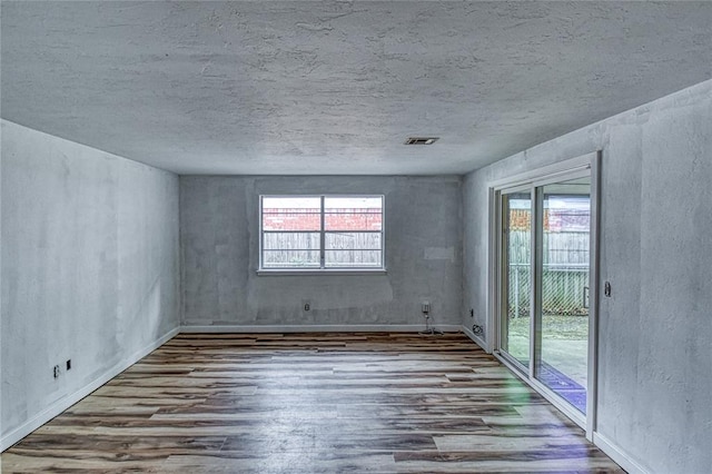 1540 Bradley Pl, Oklahoma City, OK 73127 - spare room featuring wood finished floors and a textured ceiling