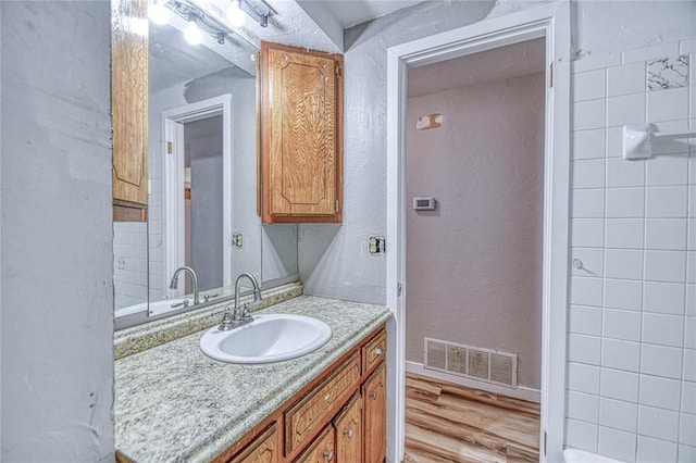 1540 Bradley Pl, Oklahoma City, OK 73127 - bathroom featuring vanity, wood finished floors, and a textured wall