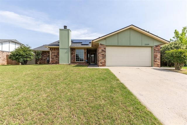 2309 Morning Glory Dr, Oklahoma City, OK 73159 - ranch-style home with an attached garage, roof mounted solar panels, a front lawn, concrete driveway, and a chimney