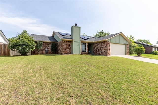 2309 Morning Glory Dr, Oklahoma City, OK 73159 - view of front facade featuring solar panels, a garage, concrete driveway, a chimney, and roof with shingles