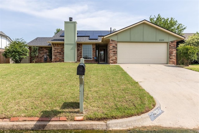 2309 Morning Glory Dr, Oklahoma City, OK 73159 - view of front facade with a chimney, an attached garage, solar panels, a front lawn, and driveway
