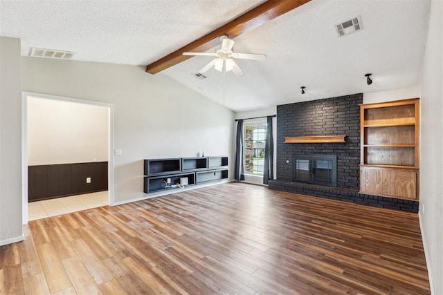 2309 Morning Glory Dr, Oklahoma City, OK 73159 - unfurnished living room featuring wood finished floors, a textured ceiling, ceiling fan, and a brick fireplace