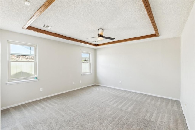 2309 Morning Glory Dr, Oklahoma City, OK 73159 - spare room with a textured ceiling, ceiling fan, carpet floors, and a raised ceiling