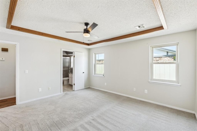 2309 Morning Glory Dr, Oklahoma City, OK 73159 - unfurnished bedroom featuring a textured ceiling, light colored carpet, ensuite bathroom, and ceiling fan