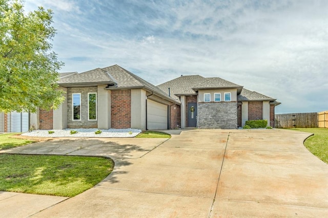 17333 Shadow Hawk Ln, Edmond, OK 73012 - prairie-style house featuring driveway, a garage, a shingled roof, and brick siding