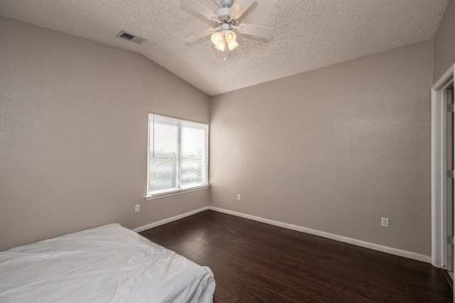 2200 Classen Blvd Unit 2131, Norman, OK 73107 - bedroom featuring dark wood-type flooring, a textured ceiling, lofted ceiling, and a ceiling fan