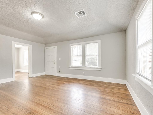 1527 NW 43rd St, Oklahoma City, OK 73118 - empty room featuring plenty of natural light, a textured ceiling, and light wood finished floors