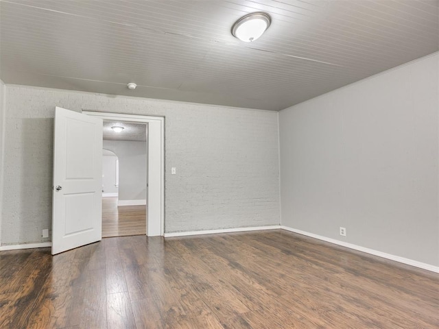 1527 NW 43rd St, Oklahoma City, OK 73118 - spare room featuring wood finished floors, brick wall, and arched walkways