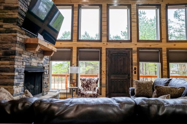 17 Honor Ct, Broken Bow, OK 74728 - living area with wood walls, a stone fireplace, and plenty of natural light