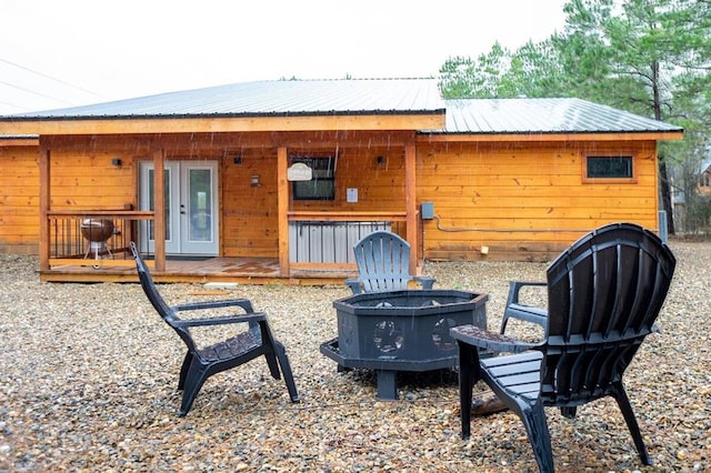 17 Honor Ct, Broken Bow, OK 74728 - rear view of house with an outdoor fire pit and a metal roof
