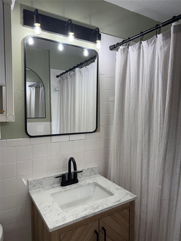 300 S Davidson Rd, Midwest City, OK 73130 - bathroom featuring tile walls and vanity
