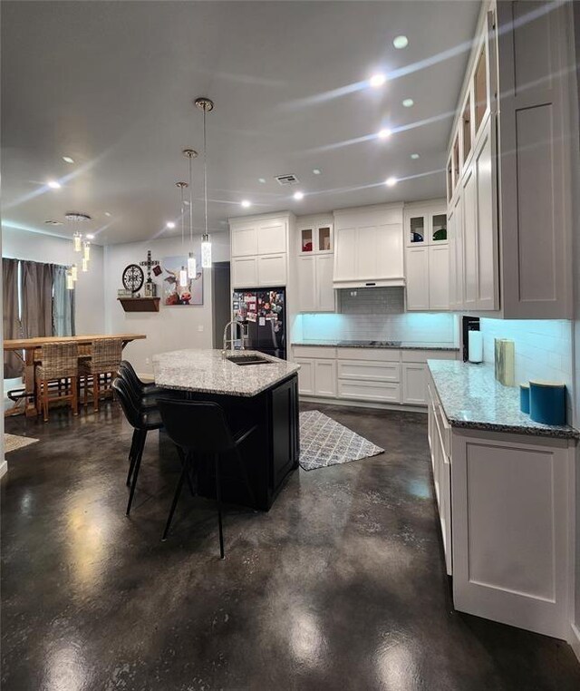 26784 Stirrup Ct, Blanchard, OK 73010 - kitchen with finished concrete flooring, custom range hood, backsplash, black appliances, and recessed lighting
