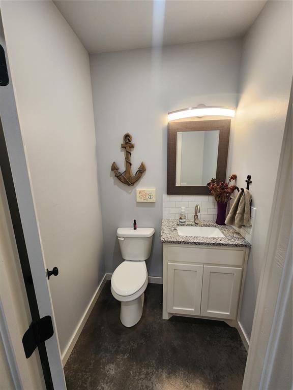 26784 Stirrup Ct, Blanchard, OK 73010 - bathroom featuring vanity, concrete floors, and decorative backsplash