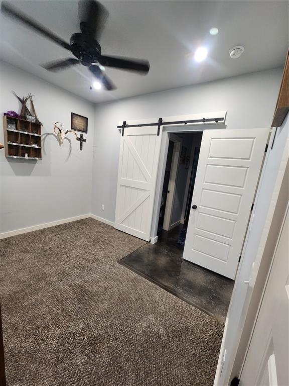 26784 Stirrup Ct, Blanchard, OK 73010 - unfurnished bedroom featuring a barn door and a ceiling fan