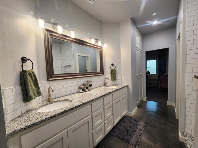 26784 Stirrup Ct, Blanchard, OK 73010 - ensuite bathroom featuring finished concrete flooring, backsplash, and double vanity