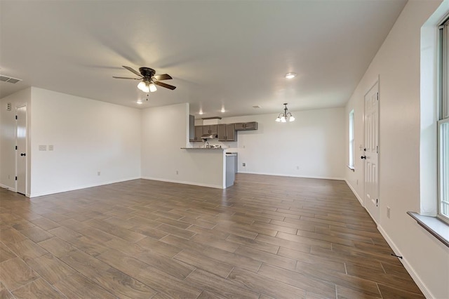 11116 SW 37th St, Mustang, OK 73064 - unfurnished living room featuring dark wood-style flooring, ceiling fan, a chandelier, and plenty of natural light