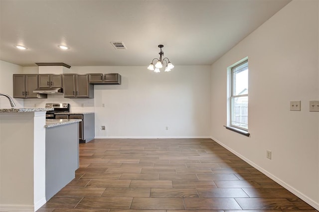 11116 SW 37th St, Mustang, OK 73064 - kitchen featuring stainless steel stove, under cabinet range hood, dark wood finished floors, a chandelier, and gray cabinets