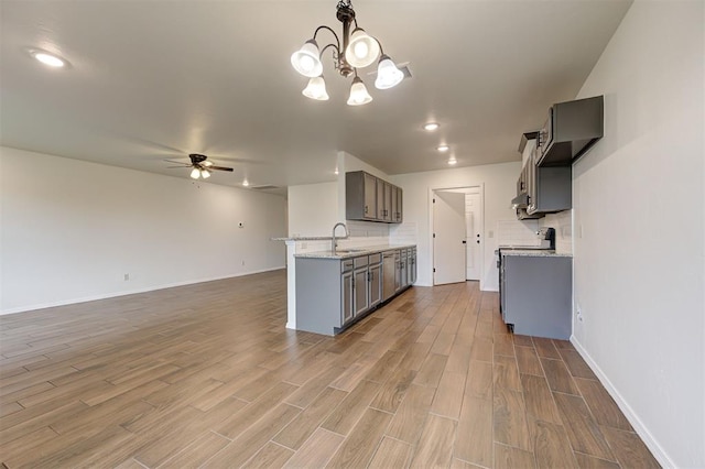 11116 SW 37th St, Mustang, OK 73064 - kitchen featuring a ceiling fan, gray cabinets, wood finished floors, backsplash, and a chandelier