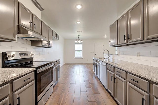 11116 SW 37th St, Mustang, OK 73064 - kitchen with stainless steel appliances, under cabinet range hood, a chandelier, gray cabinetry, and recessed lighting