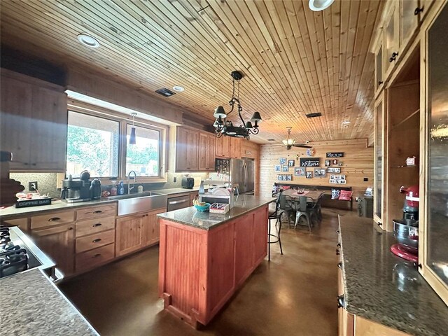 17701 S Rock Creek Rd, Shawnee, OK 74801 - kitchen featuring concrete flooring, a center island, wood ceiling, stainless steel appliances, and a breakfast bar