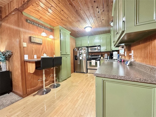 17701 S Rock Creek Rd, Shawnee, OK 74801 - kitchen featuring green cabinetry, stainless steel appliances, wooden ceiling, wooden walls, and light wood-style floors