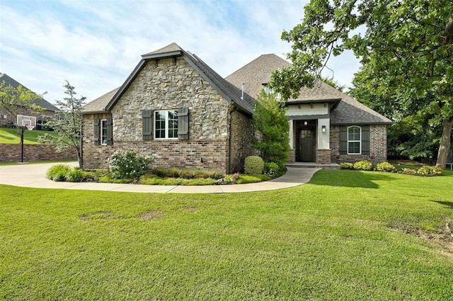 2473 Vellano Ln, Edmond, OK 73034 - view of front of property with a front yard, brick siding, stone siding, and a shingled roof